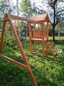 drewniana konstrukcja zabawy z huśtawką w trawie w obiekcie Bekecs Vendégház w mieście Nagyvisnyó