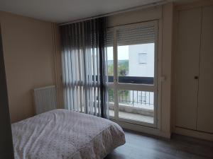 sypialnia z łóżkiem i dużym oknem w obiekcie Grand et superbe appartement proche Paris w mieście Creil