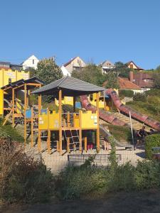 un parque con parque infantil con una montaña rusa en Galeria Villa en Veszprém