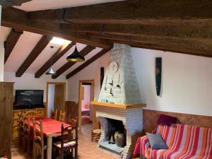 - un salon avec une cheminée, une table et des chaises dans l'établissement Apartamento Rural Cardera en la Sierra de Cazorla, à Beas de Segura