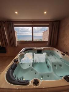 eine Whirlpool-Badewanne in einem Zimmer mit Fenster in der Unterkunft Mani Luxury Suites and Studios in Gytheio with Private Pools in Gythio