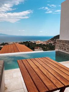 a wooden table on a balcony with a view of the ocean at Mani Luxury Suites and Studios in Gytheio with Private Pools in Gythio