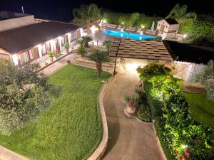 una vista aérea de un patio trasero por la noche con piscina en Le Zarafe, en Caltabellotta
