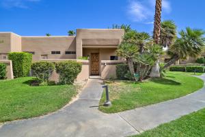 a house with palm trees and a driveway at Access to 33 Pools Cathedral City Condo with Patio in Cathedral City