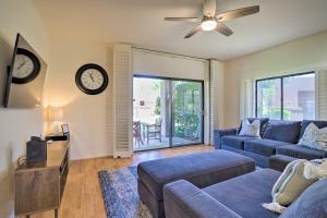 a living room with a couch and a clock on the wall at Access to 33 Pools Cathedral City Condo with Patio in Cathedral City