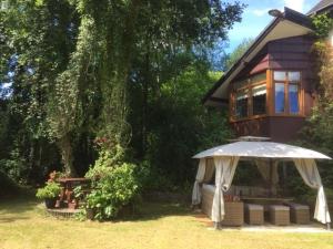 una casa con sombrilla y una mesa de picnic en el patio en Luxury Suite in quiet countryside location, en Swansea