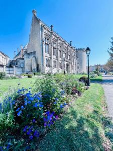 an old house with flowers in front of it at Charmante maison proche Hôtel de ville in Angoulême