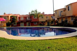 a swimming pool in the middle of a yard with buildings at Luxury Home Ixtapa Balcony Pool BBQ AA WIFI 250mbs! in Ixtapa
