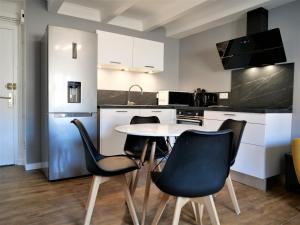 kuchnia ze stołem i krzesłami w pokoju w obiekcie Appartement moderne entièrement rénové w mieście Aurillac