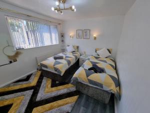 1 dormitorio con 2 camas y ventana en Glamorous room with WiFi and Netflix en Leeds