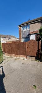 a wooden fence in front of a house at Glamorous room with WiFi and Netflix in Leeds