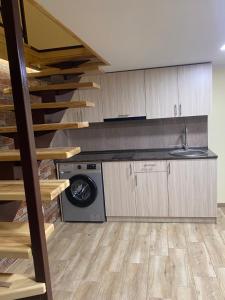 a kitchen with a washing machine and a staircase at Танхаус in Dilijan