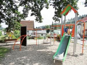 a playground with a green slide in a park at Pod Dębem in Jugów