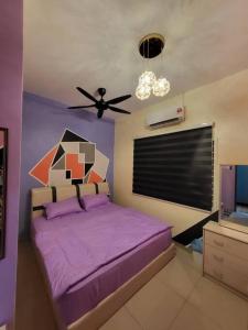 a bedroom with a purple bed with a ceiling fan at ADN LUXURY Homestay KARAOKE, POOL,NETFLIX,ASTRO,BBQ in Port Dickson