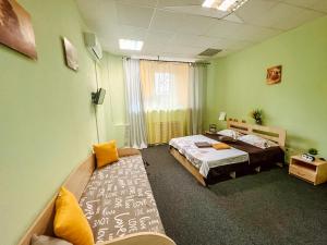 a room with two beds and a couch in it at Mini Hotel near Arena City in Kyiv