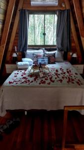 a bedroom with a large bed with roses on it at Vista dos Canyons in Praia Grande