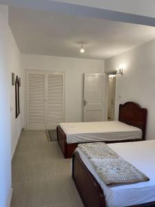 a room with two beds and two closets in it at Cheerful fully furnished 3 bedroom villa in North Coast in Dawwār Abū Maḩrūs