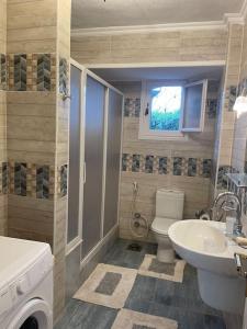 baño con aseo y ventana en Cheerful fully furnished 3 bedroom villa in North Coast en Dawwār Abū Maḩrūs