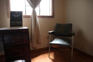 una silla sentada en una habitación con ventana en Roma Norte Hostal en Ciudad de México