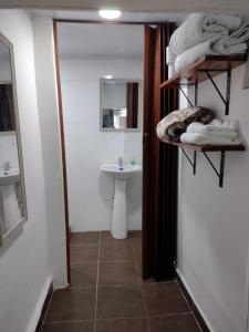 y baño con lavabo, aseo y toallas. en El Hostal By Pochet, en San Andrés