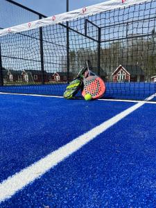 HammarにあるHarge Bad & Campingのテニスボールとテニスコートのラケット