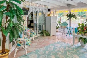 a living room with a refrigerator and some plants at Pams Mermaid House with Riverfront Yard and Lanai! in Weeki Wachee