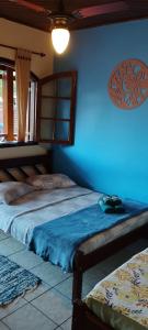 a bedroom with two beds and a blue wall at Pousada Exuberante in Abraão