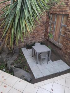a table and a chair in front of a brick building at Bikkurim Inn in Nelspruit