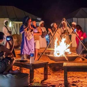 a group of people standing around a fire at Bivouac ZAGORA in Zagora