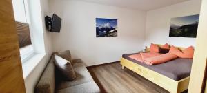ナウダースにあるApart Alpenflairのベッドルーム1室(オレンジ色の枕が付いたベッド1台付)