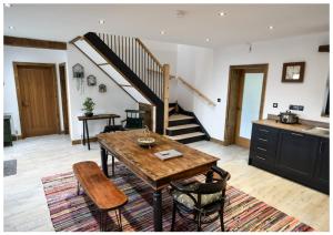 a kitchen and dining room with a table and a staircase at Mill House in Portglenone