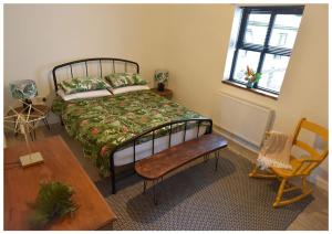 um quarto com uma cama, uma mesa e uma cadeira em Mill House em Portglenone