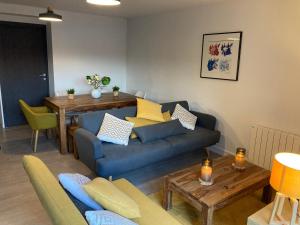 ein Wohnzimmer mit einem blauen Sofa und einem Tisch in der Unterkunft Label OR appartement spacieux proximité pistes in Les Deux Alpes