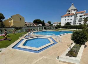 a large swimming pool in front of a building at The Olive Tree Vilamoura Centre in Vilamoura