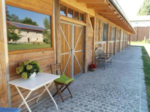 a patio with a white table and chairs on a wooden building at Korn-Hof in Kornatice