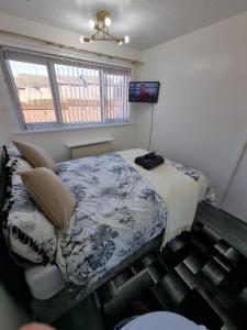 a bedroom with a bed and a television in it at Modern & Elegant Home w/ Netflix and Parking in Leeds