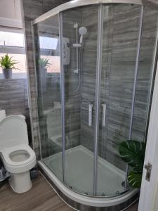 a glass shower in a bathroom with a toilet at Modern & Elegant Home w/ Netflix and Parking in Leeds