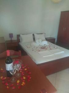 Simos Apartments في كورينوس: غرفة نوم بسرير وطاولة عليها قلوب