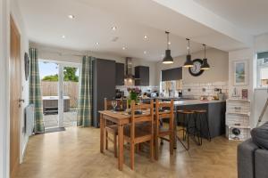 a kitchen and living room with a wooden table and chairs at Acorn Cottage in Tenby