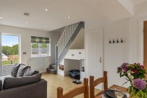 a living room with a couch and a table at Acorn Cottage in Tenby