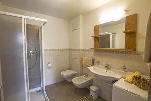 a bathroom with a toilet and a sink and a shower at Apartements Precalalt in La Villa