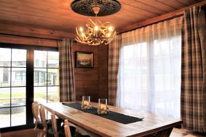 a dining room with a wooden table and a chandelier at The Bavarian Chalet in Ohakune