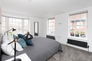 a bedroom with a bed and two windows at Hampden Apartments - The Louis in Eton