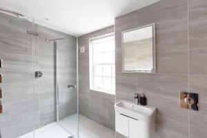 a bathroom with a shower and a sink and a mirror at Hampden Apartments - The Louis in Eton +8 photos