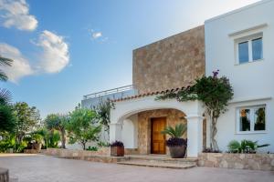 a white house with a courtyard and trees at Villa Can Joan I - Fantastic Sunset Views and Family Friendly - in San Antonio