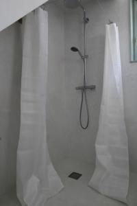 y baño con ducha y cortinas blancas. en Les Jardins d'Olus en Wandignies-Hamage