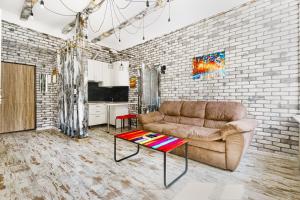 Odessa的住宿－Loft on Mayakovsky 9，带沙发和砖墙的客厅