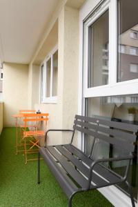 a bench sitting on a balcony with a table at Charmant 2 pièces proche de Paris in Villeneuve-la-Garenne