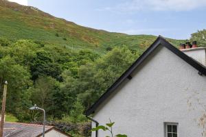 a white house with a mountain in the background at Heathercliffe Cottage, Snowdonia National Park in Penmaen-mawr +19 photos