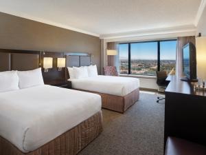a hotel room with two beds and a large window at Sonesta San Jose - Milpitas in Milpitas
